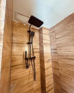 a shower in a room with a wooden wall at Retro Flat in Caruaru