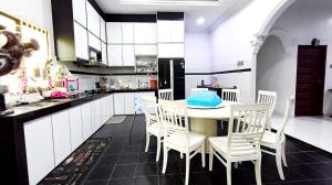 a kitchen with a table and chairs and a kitchen with white cabinets at Casa Ariana Machang 3B3R in Macang +8 photos