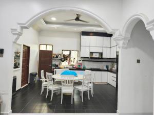 a kitchen with a table and chairs in a room at Casa Ariana Machang 3B3R in Macang