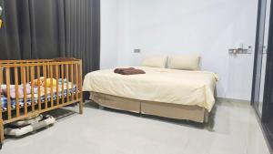 a bedroom with a bed and a crib with bottles at Casa Ariana Machang 3B3R in Macang