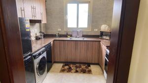 a small kitchen with a sink and a dishwasher at لوزان ابارتمنت in Dawwār Siwākah