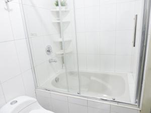a white bathroom with a shower and a toilet at EmbajadaWanka in Huancayo +57 photos