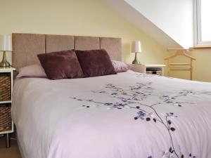 a bedroom with a white bed with purple flowers on it at Dicks View in Ventnor +5 photos