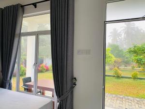 a bedroom with a door open to a patio with a table at White Shine Hotel in Polonnaruwa
