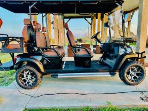 a golf cart with two seats sitting on a sidewalk at Pelican Pointe Home for 10 in Bolivar Peninsula