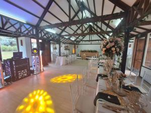 a banquet hall with white tables and chairs and flowers at Chalet Andino Sesquile in Suesca