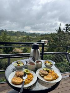 a table with two plates of food on a balcony at Gampling el Cielo los pinos in Rionegro +28 photos