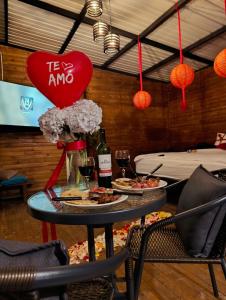 a table with two plates of food and a bottle of wine at Gampling el Cielo los pinos in Rionegro