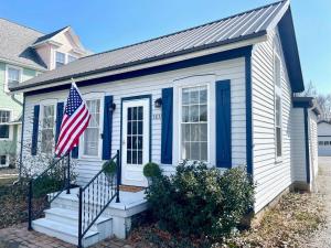 a house with an american flag in front of it at Coastal Cape Cod w/ King Bed, Game Room, & Bikes! in Vermilion