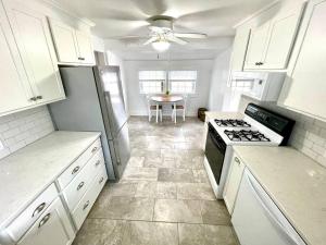 a kitchen with white cabinets and a stove top oven at Coastal Cape Cod w/ King Bed, Game Room, & Bikes! in Vermilion