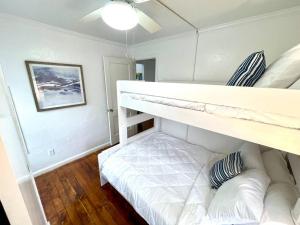 a bedroom with two bunk beds and a couch at Coastal Cape Cod w/ King Bed, Game Room, & Bikes! in Vermilion