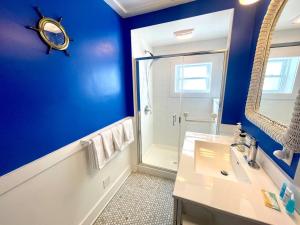 a blue bathroom with a sink and a shower at Coastal Cape Cod w/ King Bed, Game Room, & Bikes! in Vermilion +32 photos