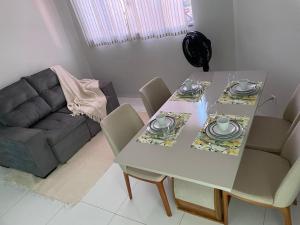 a dining room table with chairs and a couch at Estadia Executiva no Centro de Palmas in Palmas