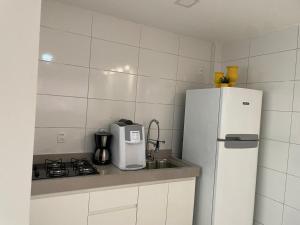 a kitchen with a white refrigerator and a stove at Estadia Executiva no Centro de Palmas in Palmas