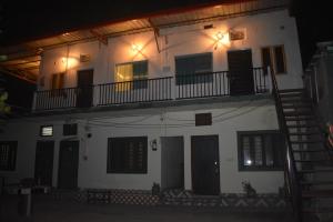a white building with a balcony and a staircase at vishranti homestayy in Rishīkesh +10 photos