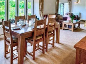 a dining room with a wooden table and chairs at Barn End in Watermillock
