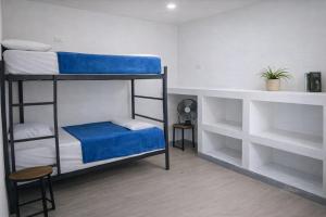 a room with two bunk beds and a desk at Casa Almarita Hostel Social Bar in Medellín