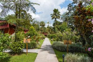 a walkway through a garden with signs at Catarata Eco Lodge in Fortuna
