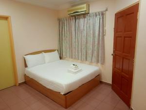 ein kleines Bett in einem Zimmer mit Fenster in der Unterkunft BBHotel in Gerik
