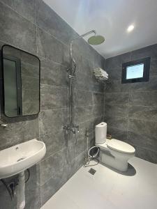 a bathroom with a toilet and a sink at Windy Beach House 1 in Ấp Bình Tú