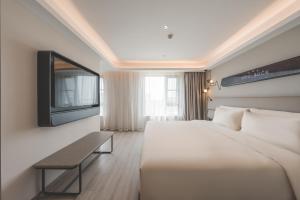a hotel room with a bed and a tv at Atour Light Hotel Hangzhou Xiasha in Hangzhou