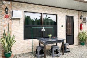 a black table and stools in front of a building at PEPAYEN Homestay in General Luna