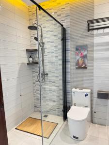 a bathroom with a toilet and a glass shower at Résidence MBK Suite in Ziguinchor +41 photos