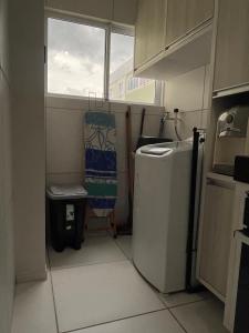 a small kitchen with a refrigerator and a window at Ap condomínio Bosque com piscina in Garanhuns +21 photos
