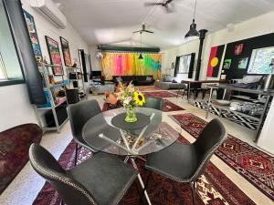 a living room with a glass table and chairs at Bellingen Disco Studio in Gleniffer