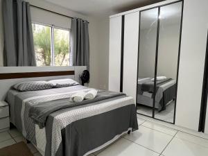 a bedroom with a bed and a large mirror at Ap condomínio Bosque com piscina in Garanhuns