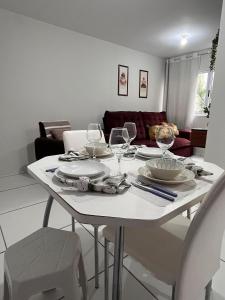 a white dining room table with wine glasses on it at Ap condomínio Bosque com piscina in Garanhuns