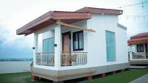 a small white house with a balcony on a lawn at Lakeside TELL Cikarang in Ceper 2
