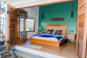 a bedroom with a bed and a green wall at Mantra Yoga Homestay in Tanjung +61 photos