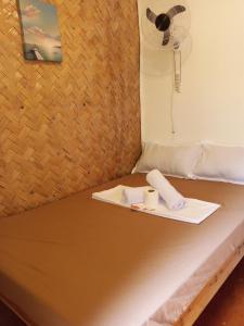 a bed with two towels and a fan on it at C and C Place in San Vicente +12 photos