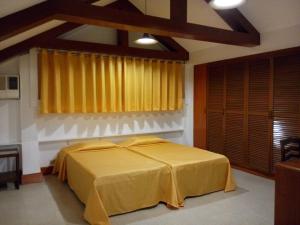 a bedroom with a bed with a yellow blanket at Pension Natividad in Manila