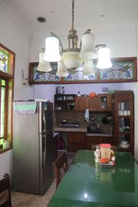 a kitchen with a green table and a refrigerator at Rumah Panjaitan in Yogyakarta