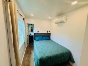 a bedroom with a green bed in a room at Hibiscus Hale - Perfect for 2! in Waialua