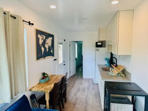 a kitchen with a table and a dining room at Hibiscus Hale - Perfect for 2! in Waialua