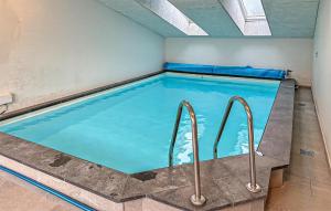 a swimming pool with blue water in a building at Amazing Home In Ørsted With Sauna in Ørsted