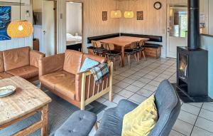 a living room with a couch and a wood stove at Amazing Home In Ørsted With Sauna in Ørsted