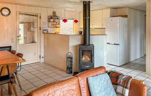 a living room with a couch and a stove at Amazing Home In Ørsted With Sauna in Ørsted