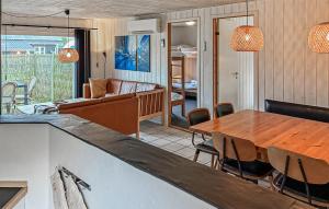 a living room with a wooden table and chairs at Amazing Home In Ørsted With Sauna in Ørsted