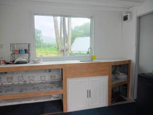 a kitchen with a sink and a window at ไร่เติมรัก - บ้านภูตระการ in Ban Khlong Kum