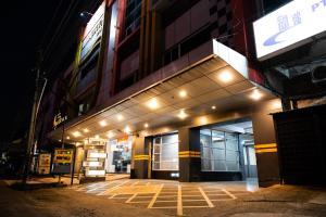 a building with lights on the side of it at night at Tripletree Majestiq Hotel in Pekanbaru