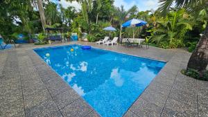 ein blauer Swimmingpool mit einem Tisch und einem Sonnenschirm in der Unterkunft Hotel Henry Bacalar in Bacalar + 38 Fotos