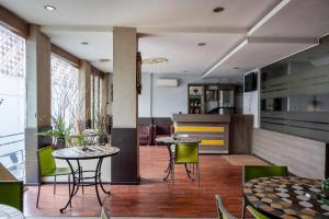 a restaurant with tables and chairs and a kitchen at Tripletree Majestiq Hotel in Pekanbaru