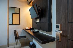 a room with a desk with a television on it at Tripletree Majestiq Hotel in Pekanbaru