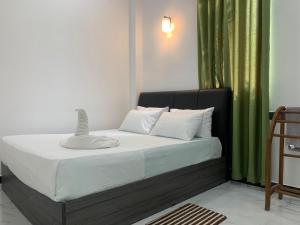 a bed in a room with a green curtain at Nomin Villa in Kottagoda