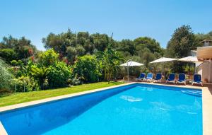 a swimming pool with chairs and umbrellas at Can Tomeu De Llubi in Llubí