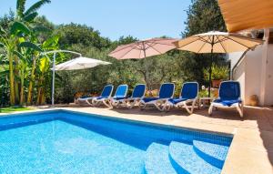 a swimming pool with chairs and umbrellas next to a swimming pool at Can Tomeu De Llubi in Llubí